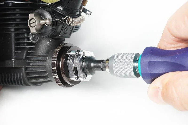 Hand using hex driver tool on RC car engine clutch assembly for maintenance