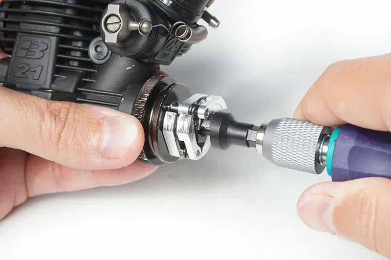 Close-up of hands using RC tool on nitro engine clutch for remote control car maintenance