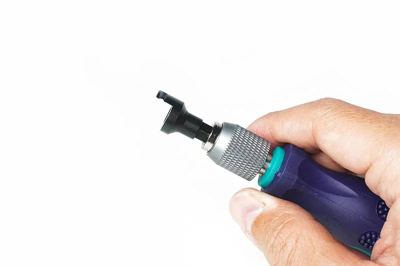 Hand holding RC car tool with ergonomic handle and metal rotating head for hobby maintenance