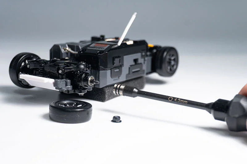 Koswork RC car tool 4.5mm hex driver in use on black RC car kit, tire and parts visible.