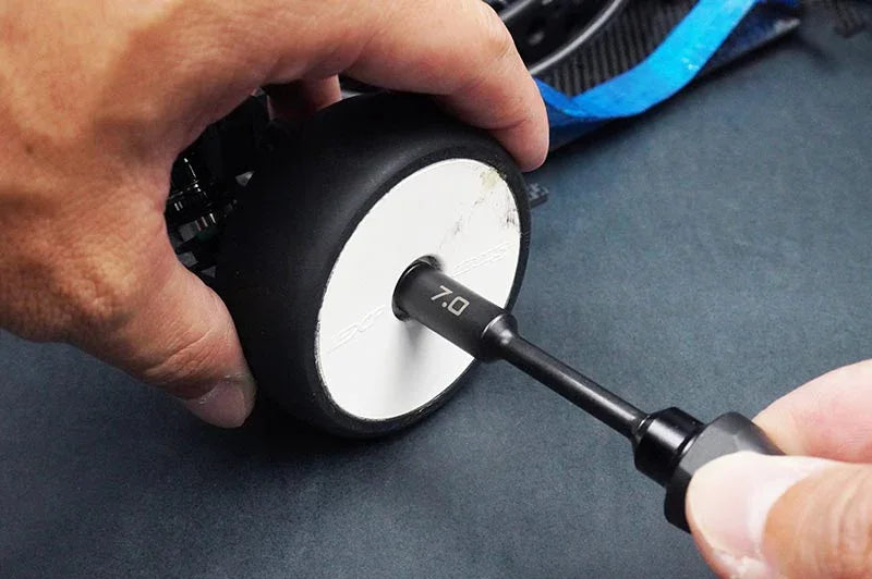 Koswork RC car 7.0mm hex driver tool in use on RC wheel, black metal handle, close-up