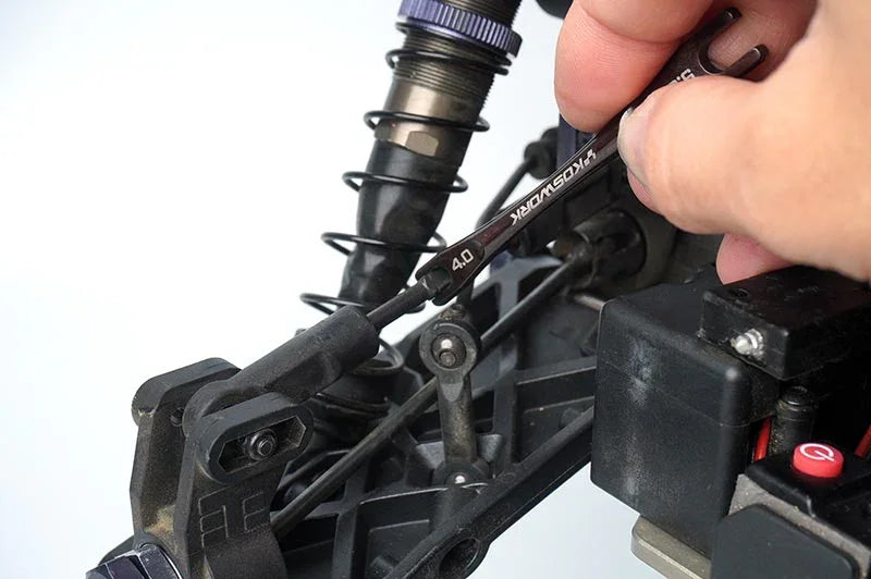 Koswork 4.0mm turnbuckle wrench adjusting RC car suspension, black metal tool, close-up view.