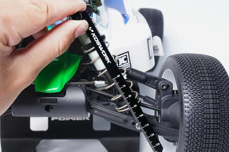 Hand using Koswork RC ride height gauge tool on RC car front suspension