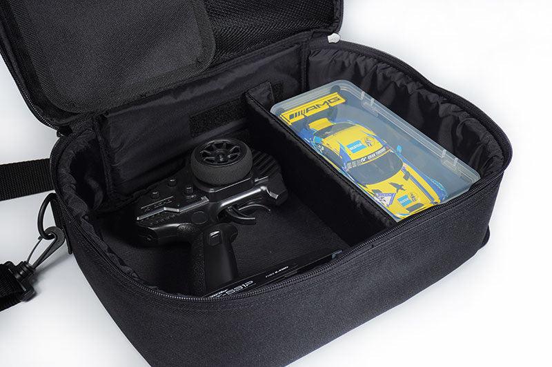 RC transmitter and mini RC car stored in a black padded carrying case with divider.