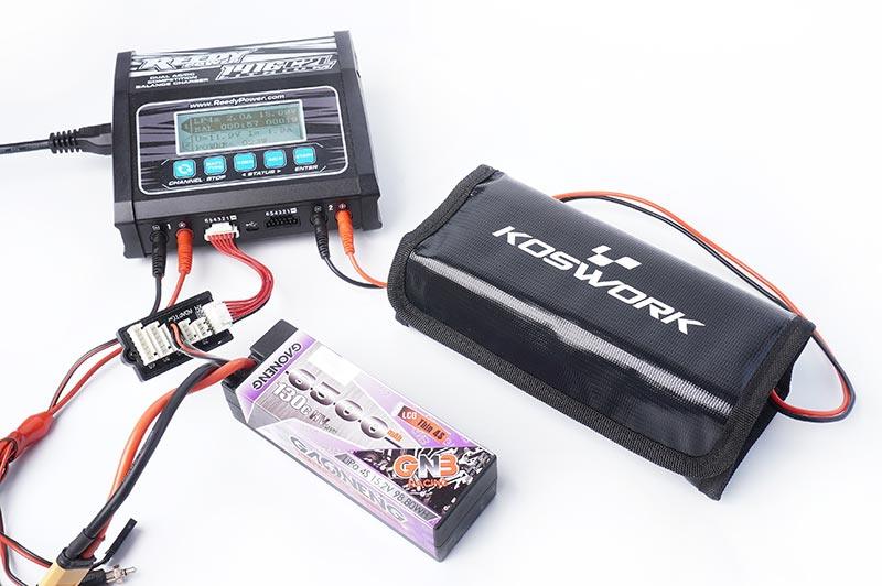 Koswork RC battery safe charging bag black nylon, product KOS32296-6, with charger and LiPo battery.