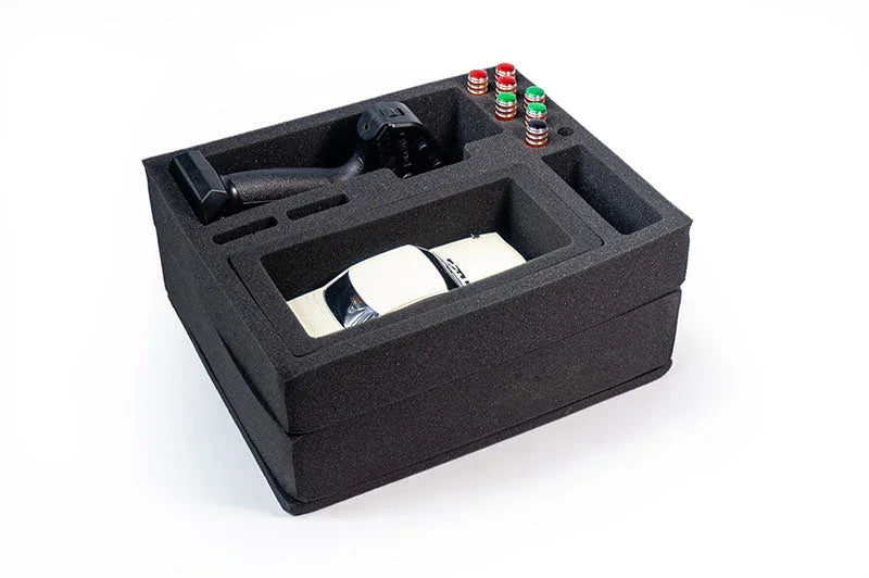 Foam insert storage tray holding a white RC car, transmitter, and RC parts on white background