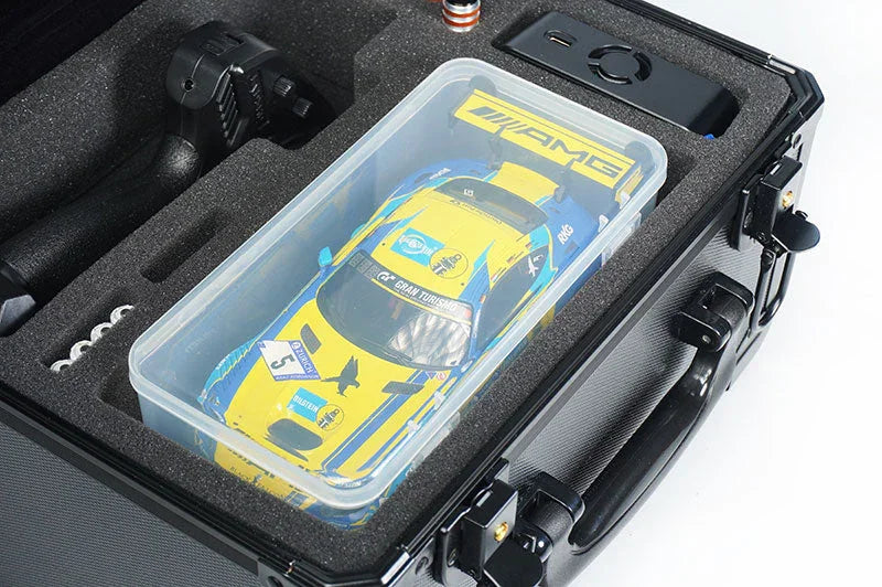 Foam-lined RC car carrying case with yellow and blue race car, remote, and accessories.