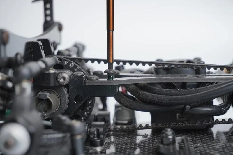 Koswork RC car tool tightening gear on chassis, black carbon material, close-up detail