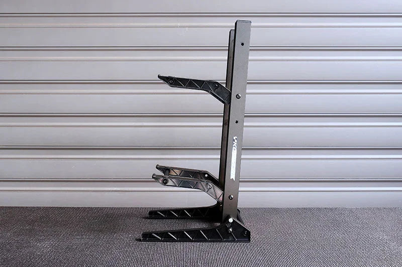 Black RC car stand with angled supports, displayed indoors on a gray background