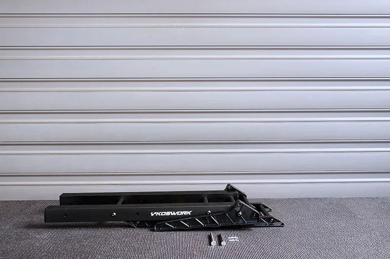 Black Koswork RC car stand with bolts, garage background, racing accessory