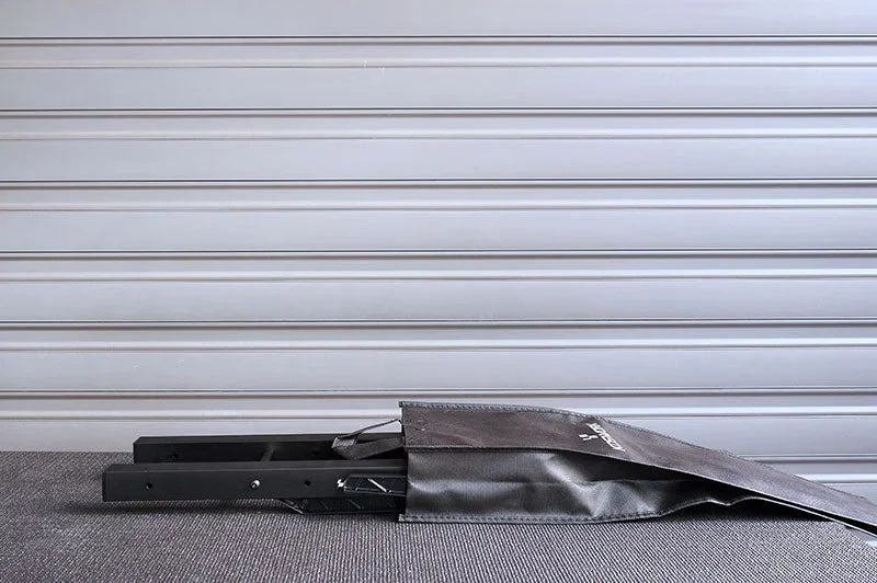 Folded RC pit bag with black handles and sturdy frame on a textured surface