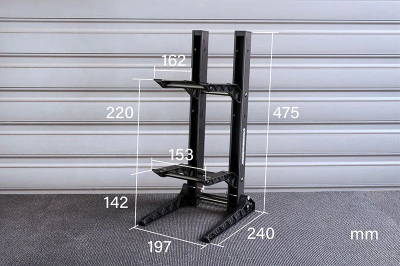 Black RC car stand with multiple measurements shown in millimeters on a textured surface.