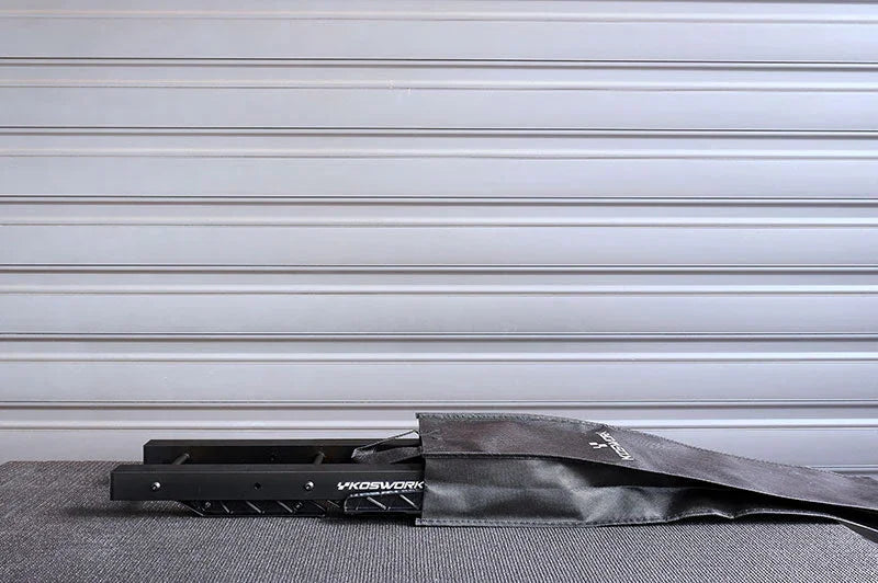RC car stand partially in black carrying bag on textured surface, metal background