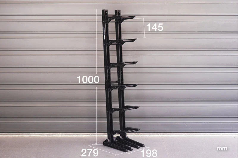 Black multi-tier RC car stand rack with dimensions labeled, standing against a gray wall